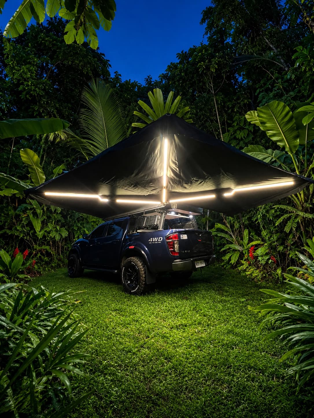 Prototype vehicle parked under an awning tent with integrated LED strip lighting at night